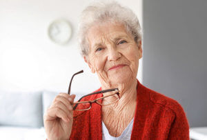 senior woman taking off glasses at exclusive senior living programs in bradenton