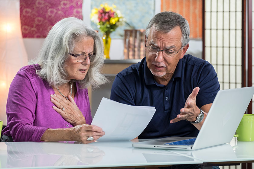 A senior aged couple looking at their bills A senior aged couple looking at their bills
