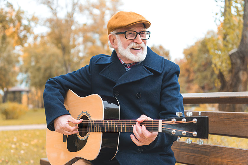 senior man playing on guitar