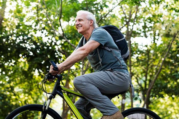 Senior man biking in the park Senior man biking in the park