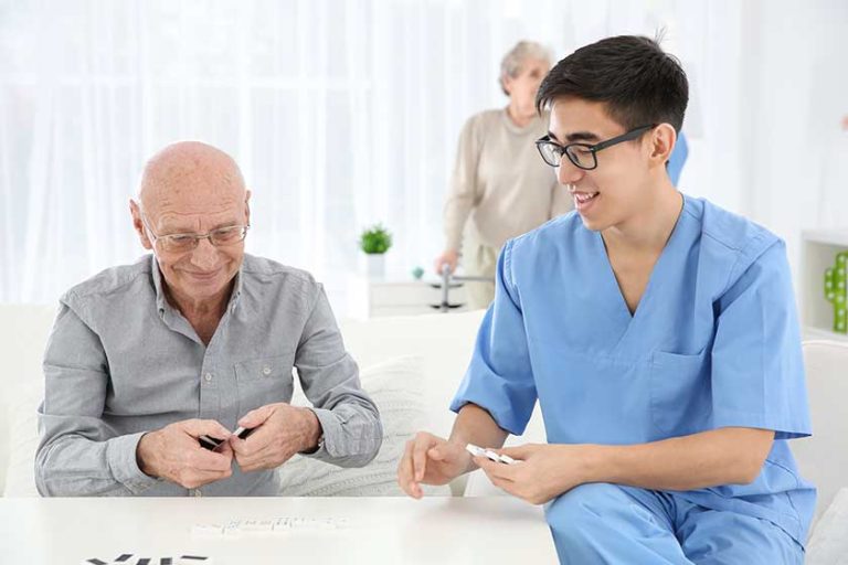 Senior man playing dominoes with young caregiver at home Senior man playing dominoes with young caregiver at home