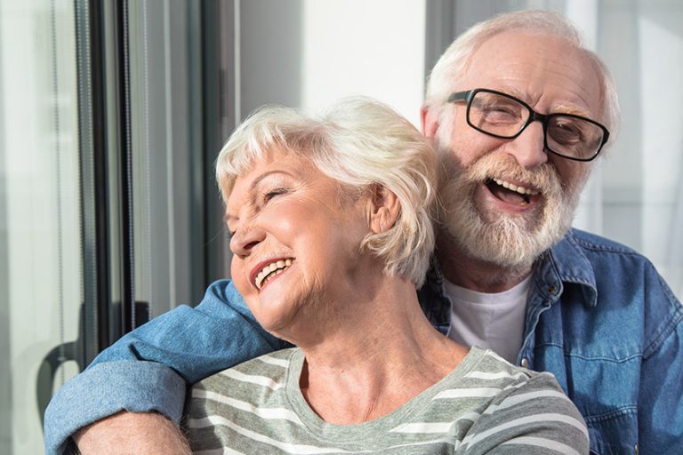 Amusement. Waist up portrait of two happy pensioners hugging each other Amusement. Waist up portrait of two happy pensioners hugging each other