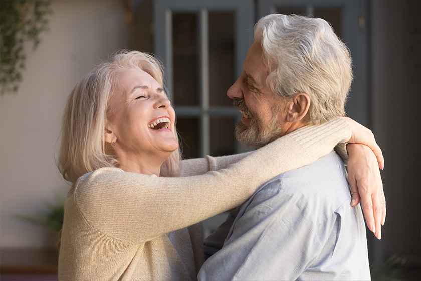 happy elderly spouses embracing standing indoors happy elderly spouses embracing standing indoors