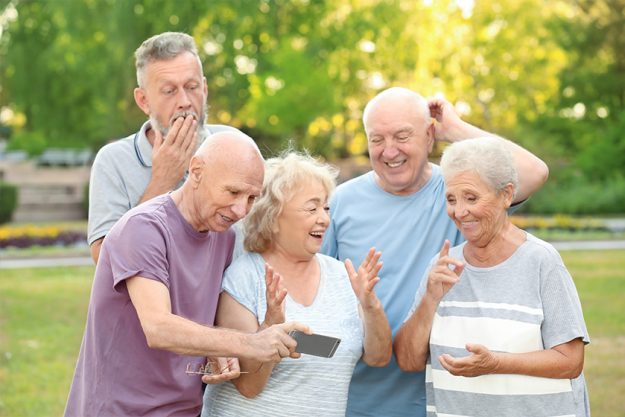 Group of elderly people with mobile phone in park Group of elderly people with mobile phone in park