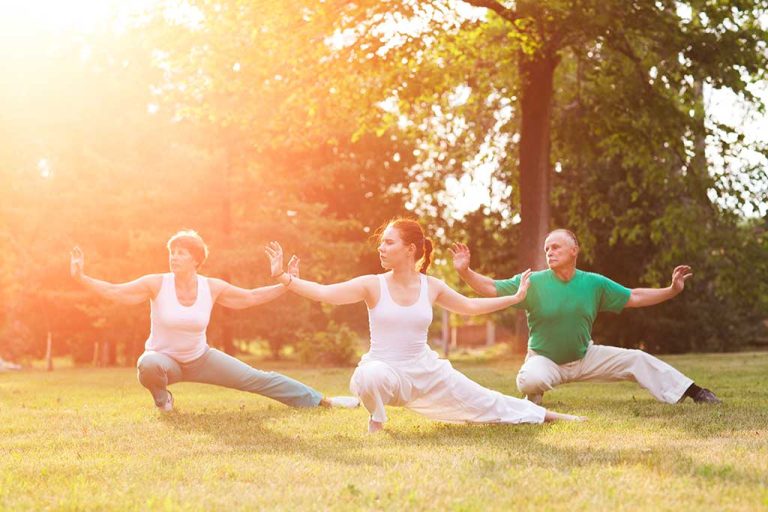 group of people practice Tai Chi Chuan in a park