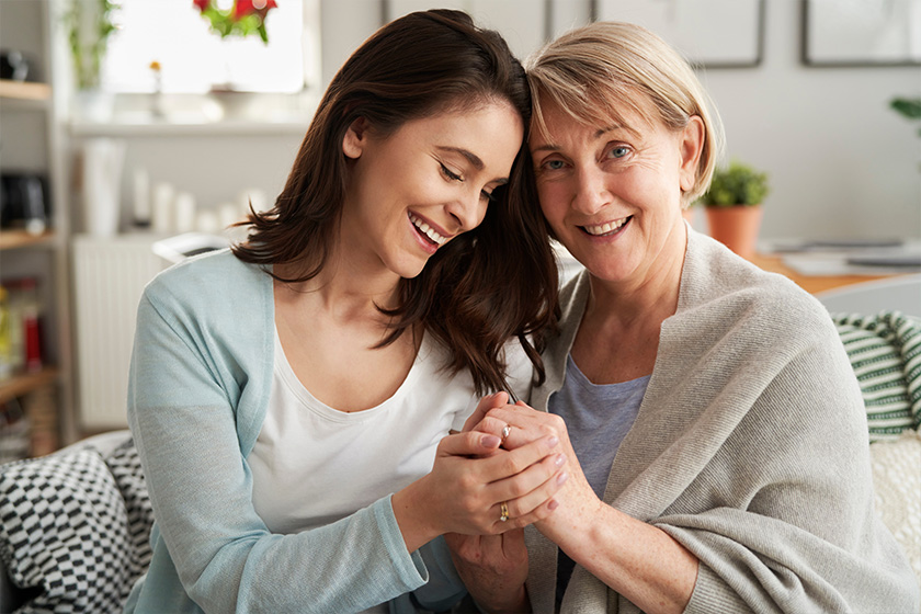 Mother and adult daughter holding hands together at home Mother and adult daughter holding hands together at home