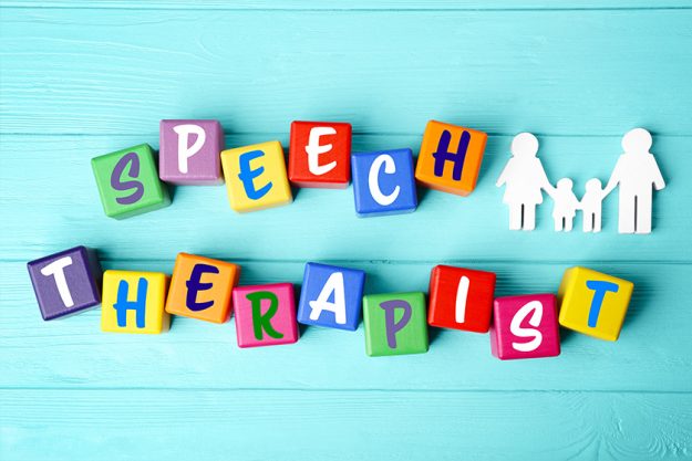 Speech therapy concept. Colourful cubes on blue wooden background Speech therapy concept. Colourful cubes on blue wooden background