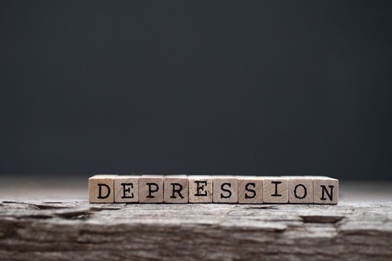 The word depression on a wood background and dark background The word depression on a wood background and dark background