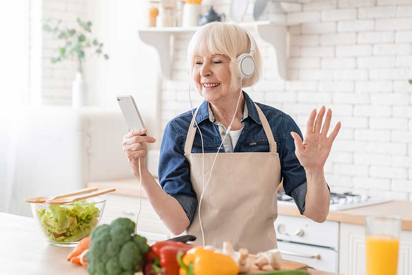 Happy old senior elderly aged grandmother woman dancing and listening to the music