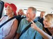 Group Of Senior Friends Sitting In Back Of Van Being Driven To Vacation