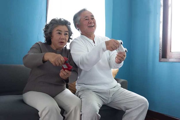 Asian Senior Couple playing video games together