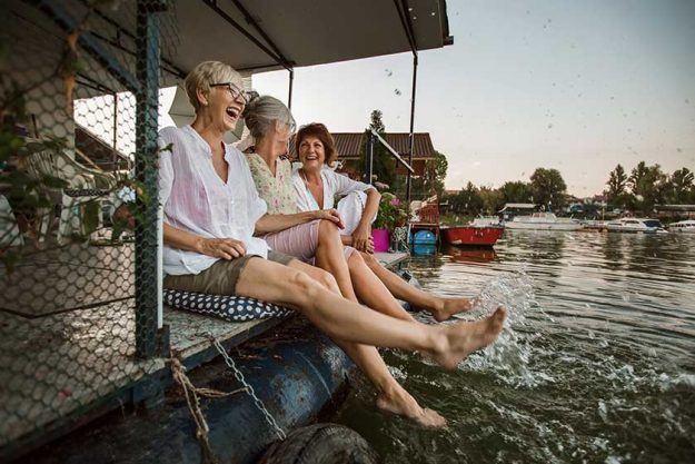 Senior female friends enjoying a day in the cottage near the river