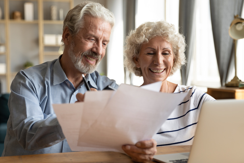 Senior couple use online banking on laptop planning family budget Paying For Memory Care Program: 4 Options You Need To Know