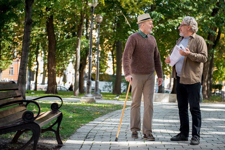 Cheerful mature friends talking in park Cheerful mature friends talking in park