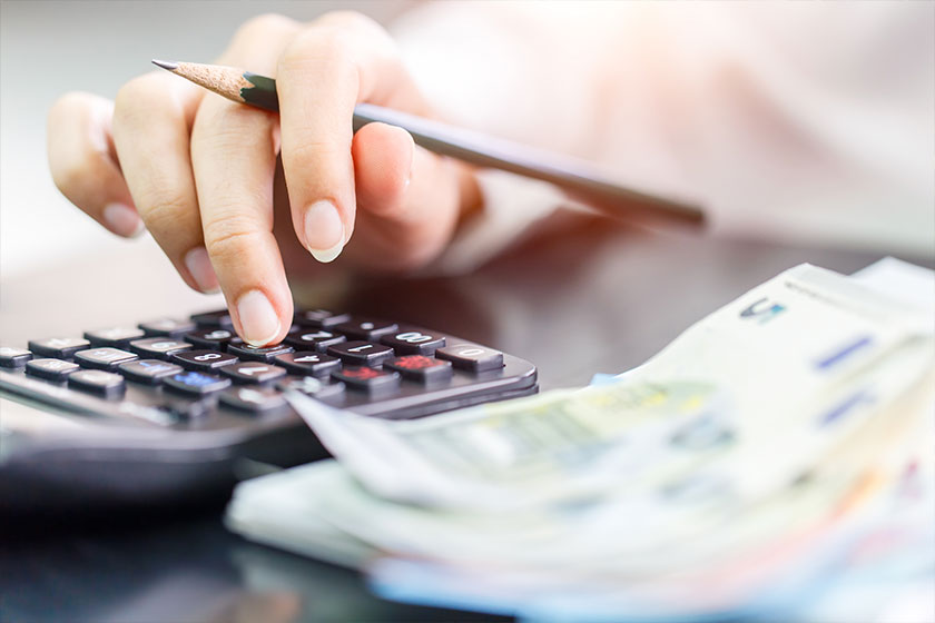 Close up right hand female using calculator