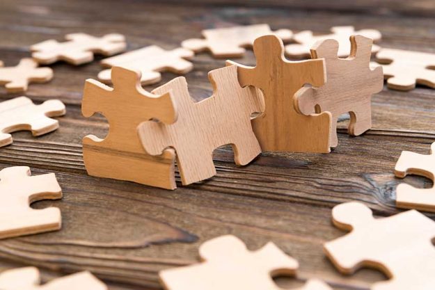 puzzles of wood on the background of a wooden table.