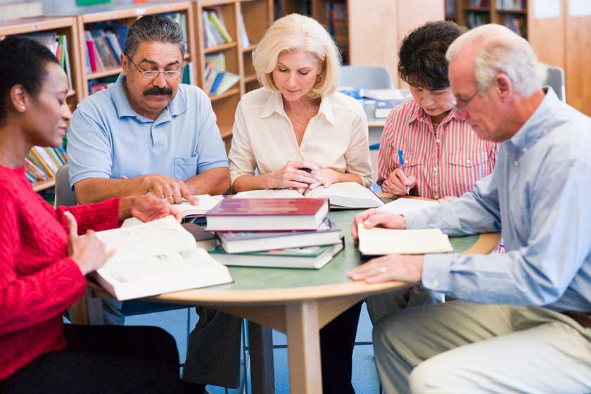 Mature students studying in a library