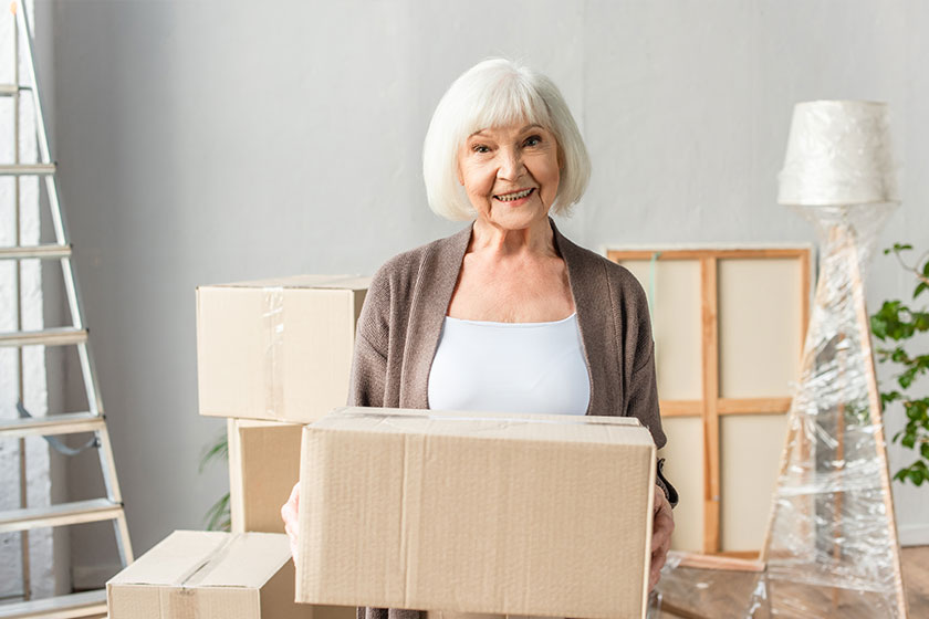 Cheerful senior woman holding cardboard box Cheerful senior woman holding cardboard box