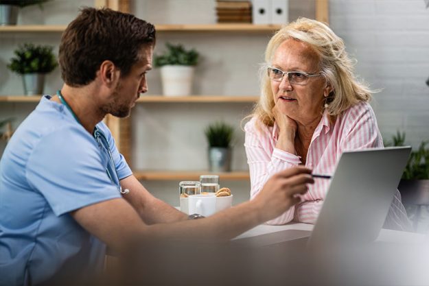 Mature Woman Listening Her Doctor Who Showing Her Medical