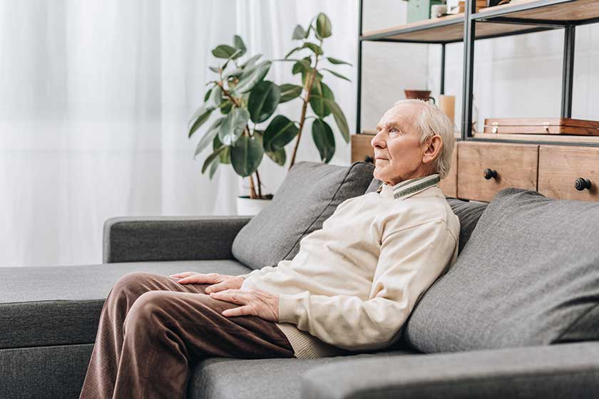 retired man with grey hair sitting on sofa retired man with grey hair sitting on sofa