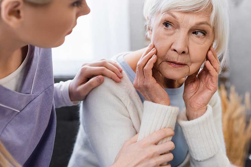 social worker touching shoulder of senior woman suffering from amnesia