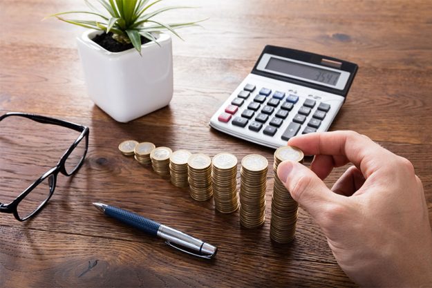Person Calculating On Wooden Desk