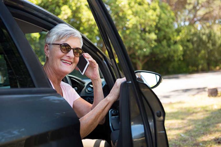 Senior woman talking on phone in car