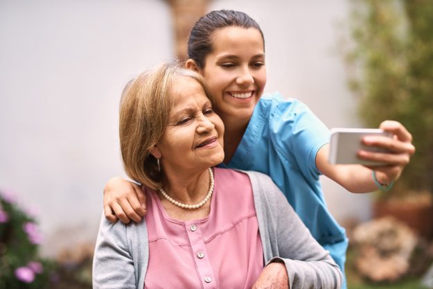 I want to capture all our memories. a caregiver taking a selfie with a senior patient outside.