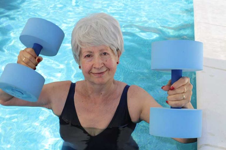 Portrait of mature woman in swimsuit with barbells Portrait of mature woman in swimsuit with barbells