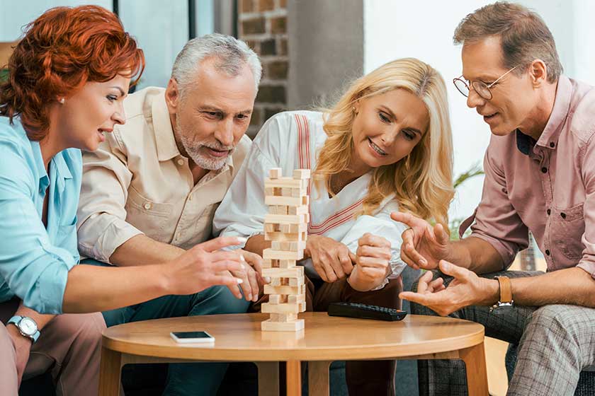 Two mature couples playing with wooden blocks