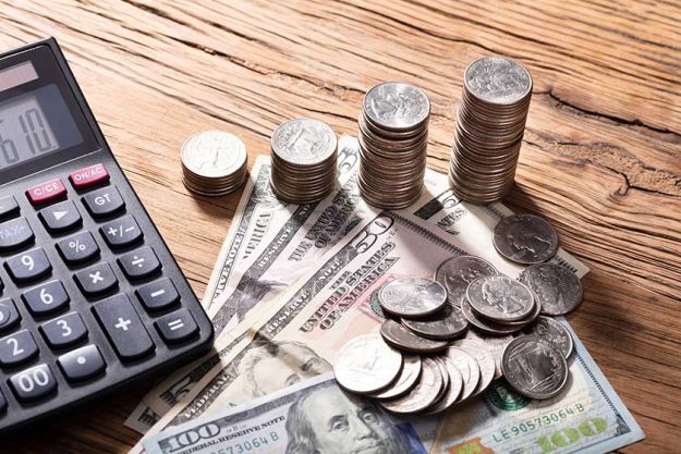 Elevated View Of Calculator With Stack Of Coins On Wooden Table Elevated View Of Calculator With Stack Of Coins On Wooden Table