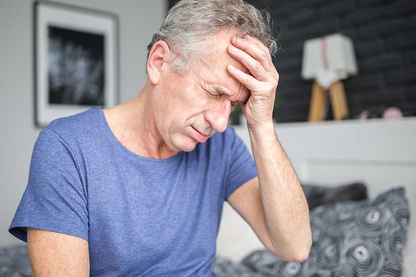 Senior man with migraine holding hand on forehead Senior man with migraine holding hand on forehead