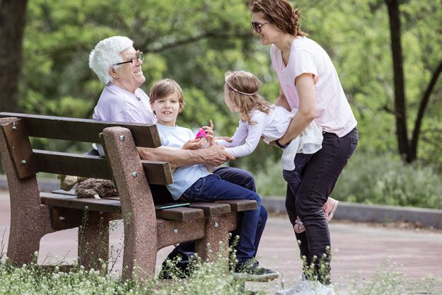 Three generation family in summer park: grandfather, mother, and grandchildren. Happy family outdoors.