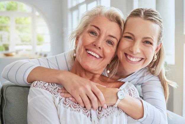 Women, hug and family bond on mothers day in a house living room and home interior. People portrait, smile and happy woman with senior and retirement elderly in trust, love and support on lounge sofa Women, hug and family bond on mothers day in a house living room and home interior. People portrait, smile and happy woman with senior and retirement elderly in trust, love and support on lounge sofa