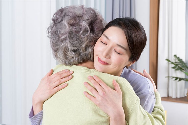 Asian old mother and middle aged daughter huggging Asian old mother and middle aged daughter huggging