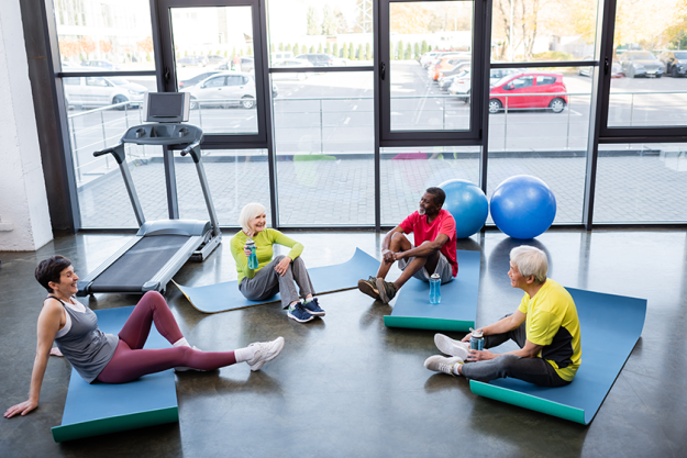 Happy interracial senior people holding sports bottles