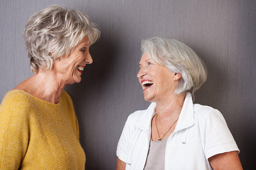 Two elderly female friends sharing a joke Two elderly female friends sharing a joke