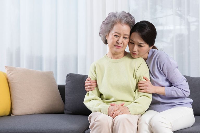 Depressed asian old mother comforted middle aged daughter
