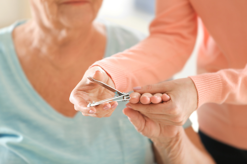 Woman manicuring hands of elderly patient, closeup