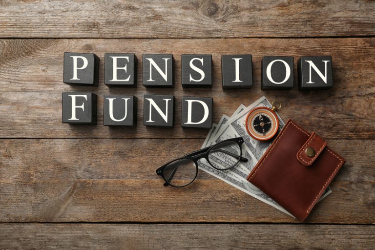 Flat lay composition with words PENSION FUND, money and compass on wooden background Flat lay composition with words PENSION FUND, money and compass on wooden background