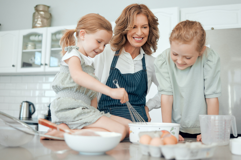 Everyone gets a turn to whisk. a grandmother baking with her two granddaughters at home.