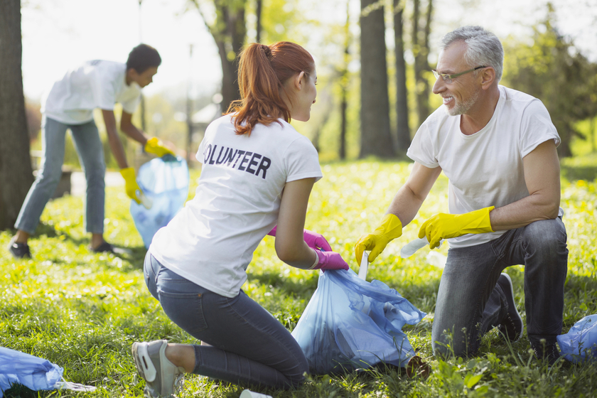 Non profit volunteer. Vigorous two volunteers holding garbage bag and chatting Non profit volunteer. Vigorous two volunteers holding garbage bag and chatting