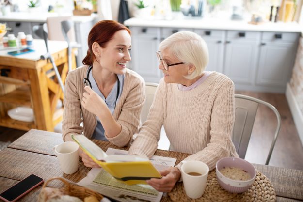 Woman and caregiver drinking tea and reading