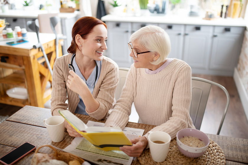 Woman and caregiver drinking tea and reading