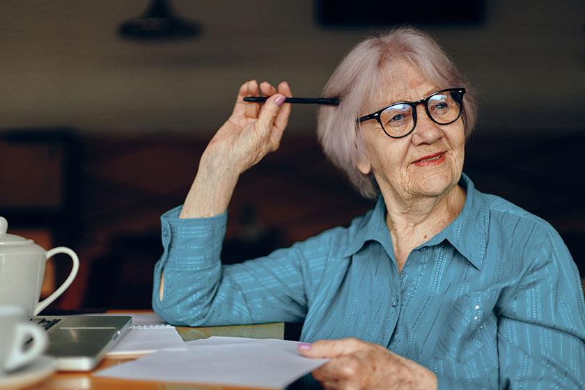 beautiful mature senior woman working in front of laptop monitor sitting lifestyle unaltered