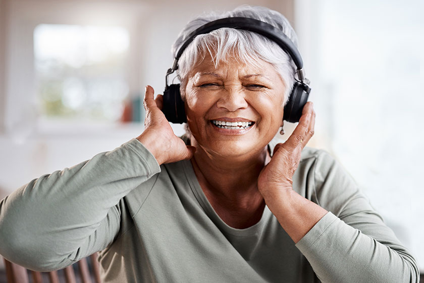 live let live beautiful senior woman listening music while sitting