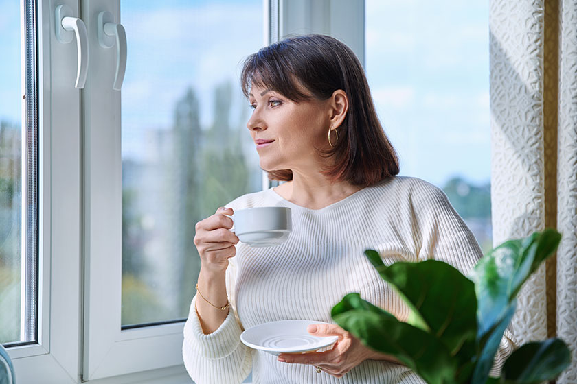 middle aged beautiful calm woman cup coffee hands home looking