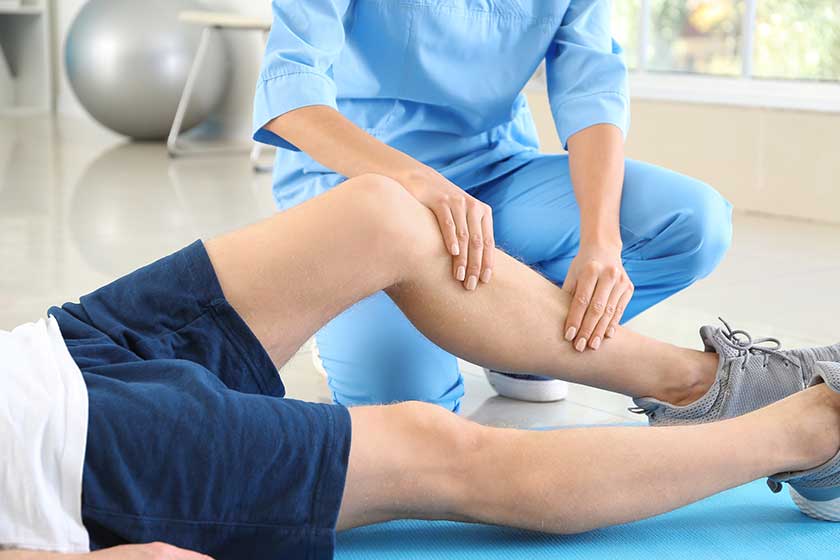 physiotherapist working with male patient in rehabilitation center