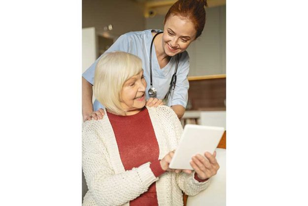 positive delighted senior woman pointing at her tablet positive delighted senior woman pointing at her tablet