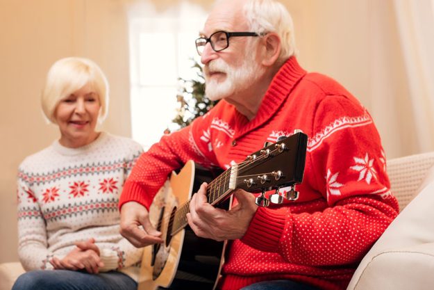 senior man playing on guitar
